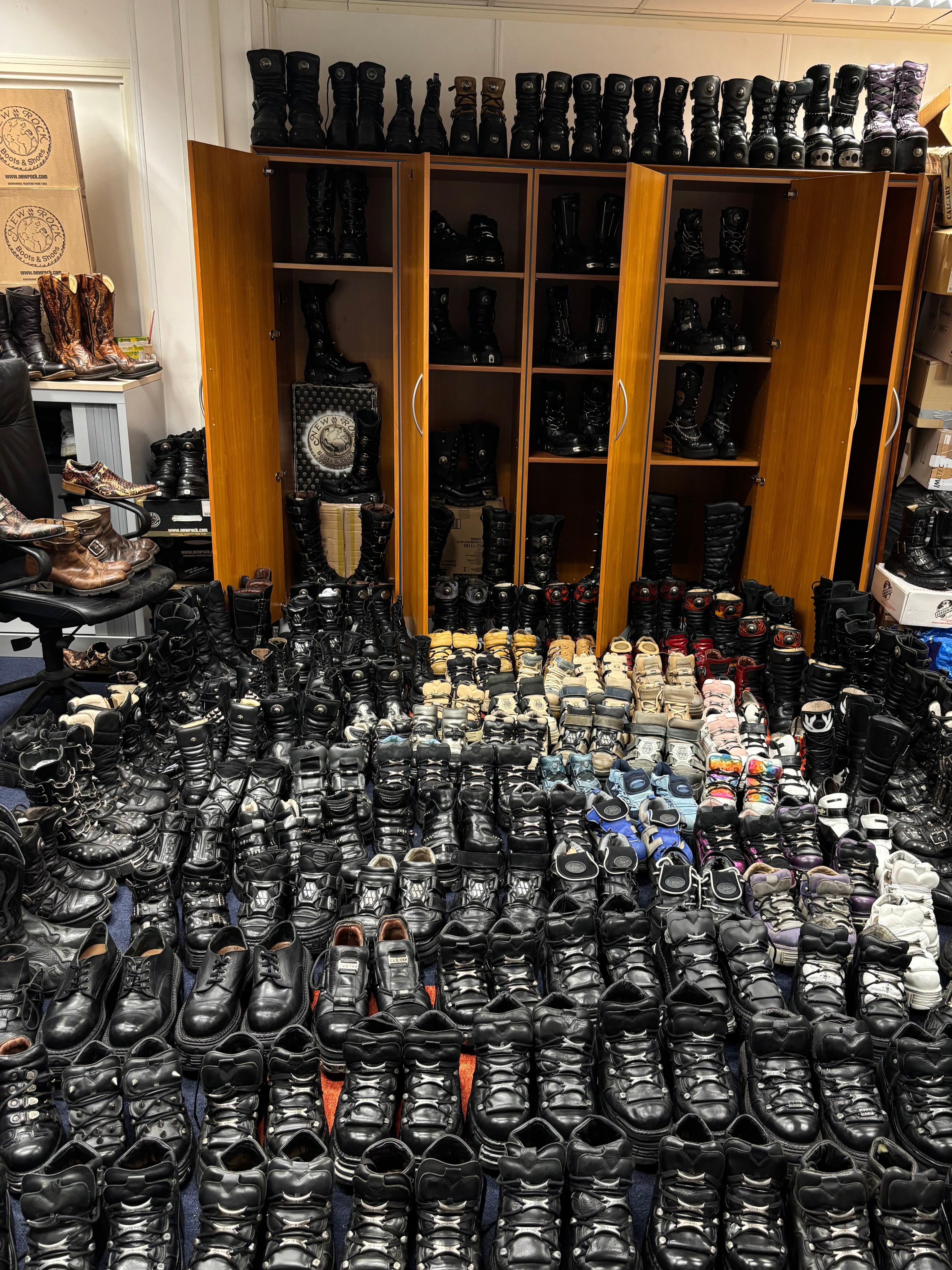 Collection of New Rock boots seen on the ground and shelves.