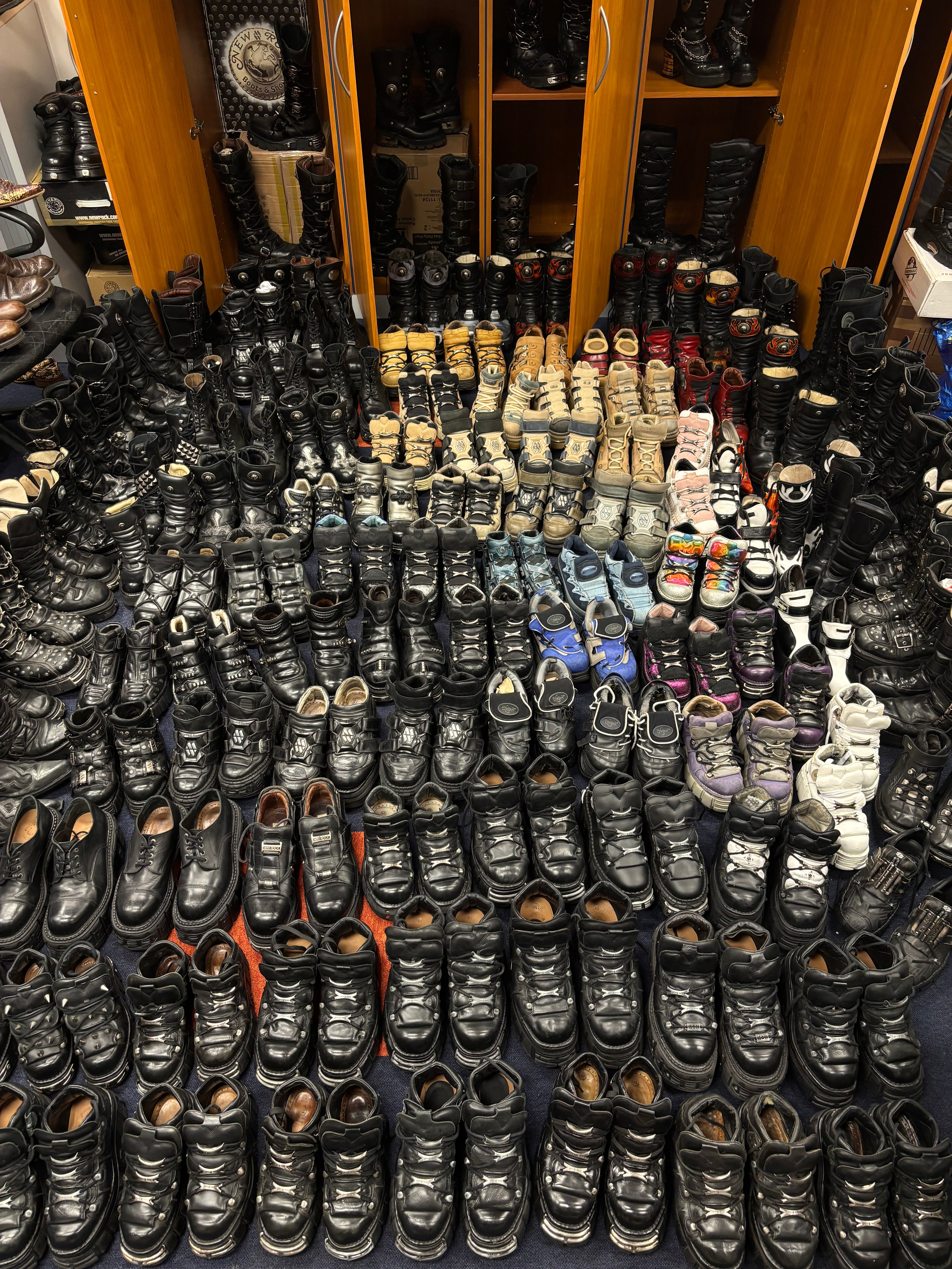 Collection of New Rock boots seen on the ground and shelves from above.